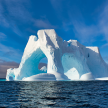 Beautiful blue waters and skies surround a massive glacier in Antarctica