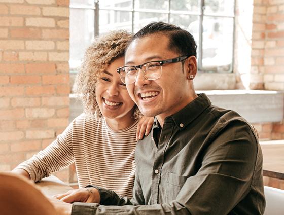 Couple looking happy while speaking to travel advisor about destination weddings