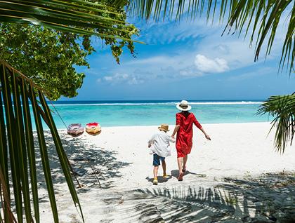 Mother and son walking on beach in Cancún, Mexico