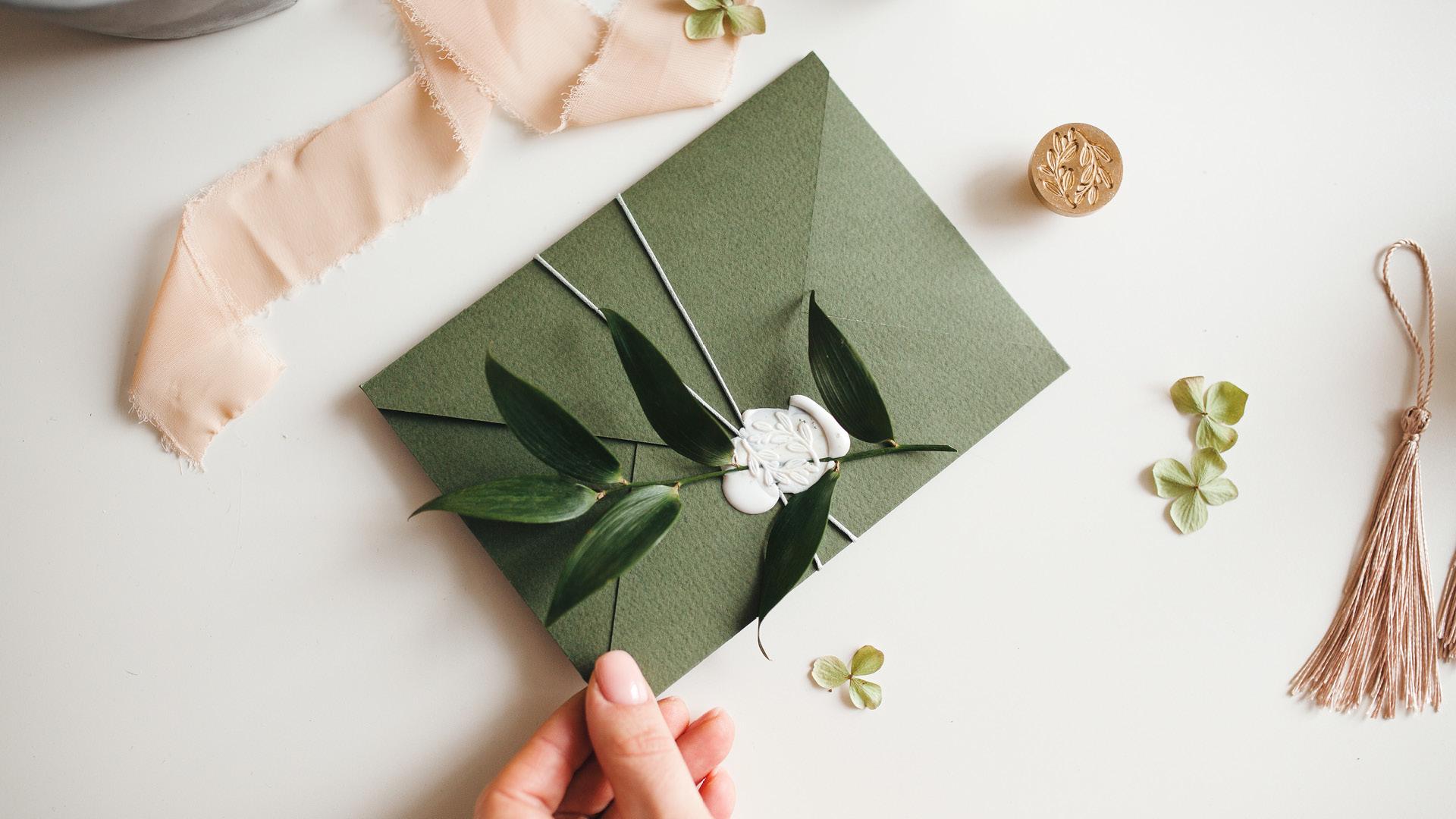 Wedding invitation in green envelope with a wax seal